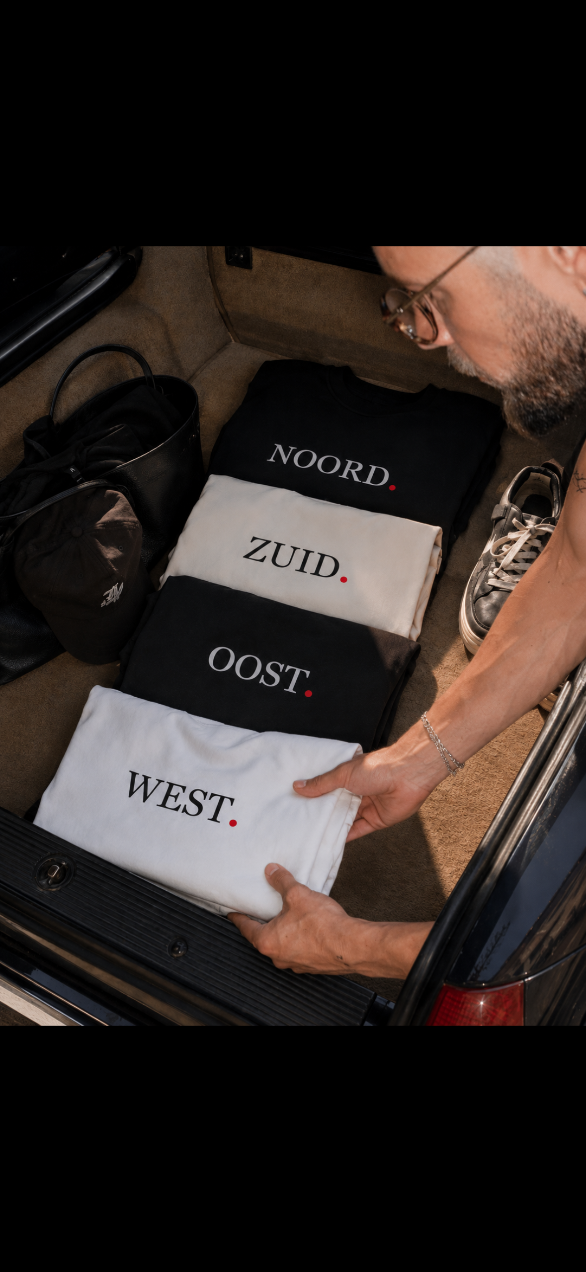 Unisex T-shirt met west noord zuid oost opdruk in zwart of wit , rode stip Wear Your City Amsterdam